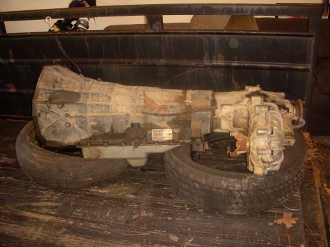 1993 Ford Bronco - A transmission unit is shown resting on two tires, likely for storage or transport.
