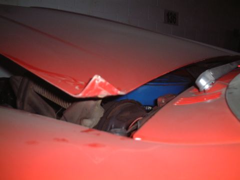 1967 Ford Galaxie - A damaged red car hood is open, revealing engine parts and a blue object.