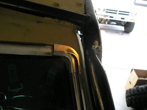 1986 Toyota Hilux - Interior view of a 1986 Toyota Hilux showing a roll cage and window frame, with another vehicle in the background.