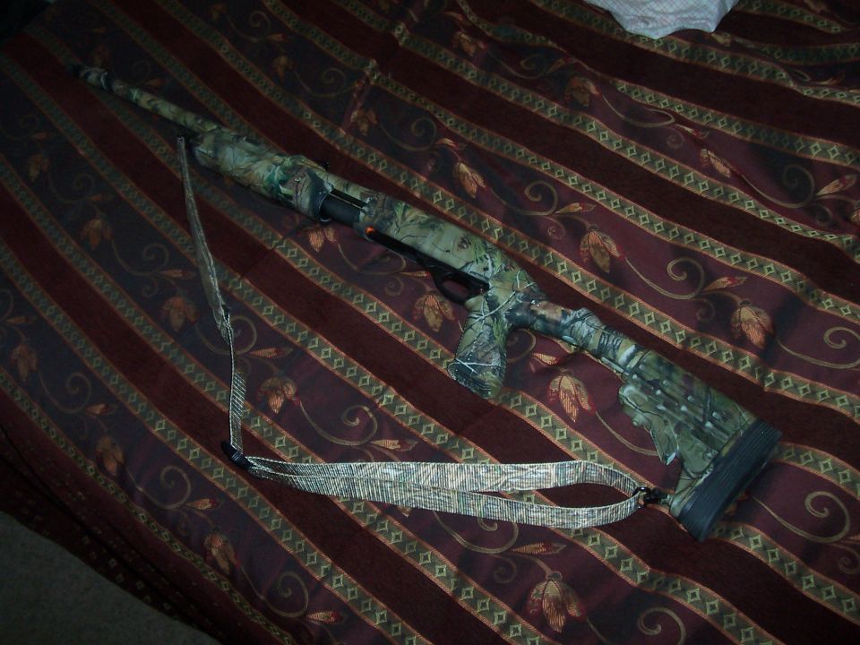 Camouflage shotgun with sling on a patterned surface