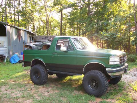 1992 Ford Bronco - This lifted 1992 Ford Bronco is painted green and black and has an ATV loaded in its bed.