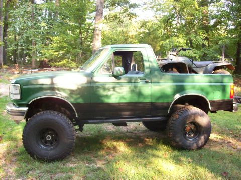 1992 Ford Bronco - This lifted Ford Bronco has an ATV loaded in its bed, ready for off-road adventure.