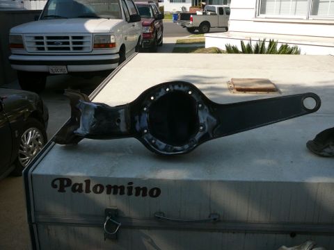 1988 Ford Bronco - A rear axle differential housing rests on a trailer, with a white Ford truck and other vehicles in the background.