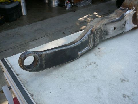 1988 Ford Bronco - A fabricated metal component, likely part of a vehicle's suspension system, rests on a concrete surface.