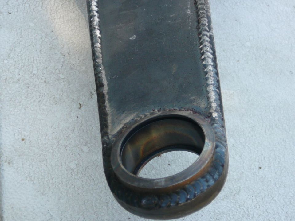 Metal suspension part with welds and a circular opening