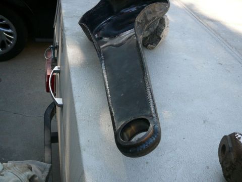 1988 Ford Bronco - Welded metal part on concrete, possibly from a vehicle's suspension or frame.