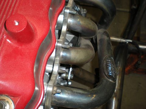 Suzuki Samurai - Engine part and exhaust manifold detail, with Supermotors.net branding visible on the pipe.