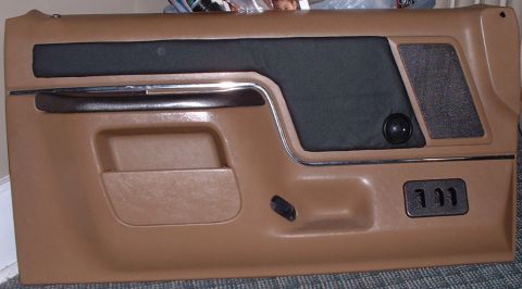 2006 Ford E350 - A brown car door panel with a black fabric insert and speaker grille is shown.