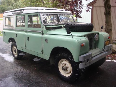 1967 Land Rover Land Rover - Light green 1967 Land Rover Land Rover parked on wet pavement.