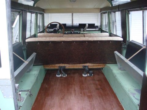 1967 Land Rover Land Rover - The interior of a 1967 Land Rover Land Rover features bench seating and a wooden floor, offering a glimpse into its utilitarian design.