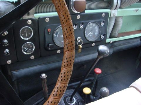 1967 Land Rover Land Rover - Interior view of a 1967 Land Rover Land Rover dashboard, showing the steering wheel, gauges, and gear levers.