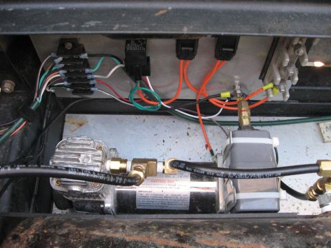 1990 Ford F-250 - Close-up view of an air compressor and electrical components within a vehicle.