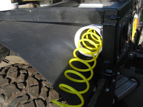 1990 Ford F-250 - A close-up view of a yellow coiled hose attached to a truck bed.