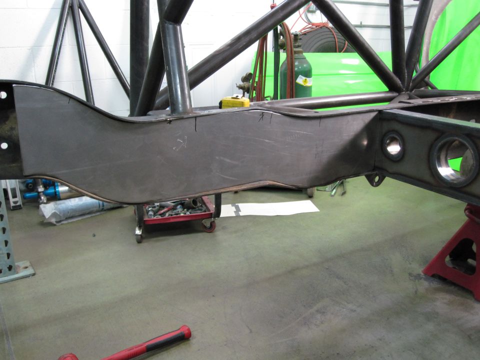 Custom fabricated metal frame section with roll cage tubing, on jack stands