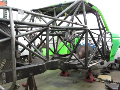 1995 Ford Bronco - Custom roll cage construction on a vehicle frame, with green body panels in the background.