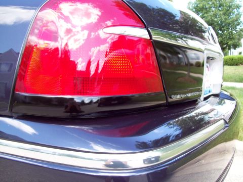 1999 Mercury Grand Marquis - Rear view of a 1999 Mercury Grand Marquis showing the taillight and chrome bumper trim.
