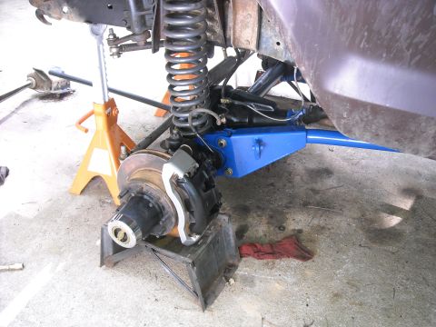 1979 Ford F-150 - Close-up of a vehicle's front suspension and brake system, undergoing maintenance.