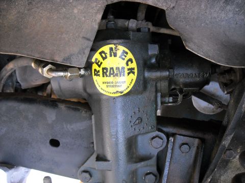 1979 Ford F-150 - A close-up view of a steering gear box, a prominent yellow sticker with text about hydro assist steering.