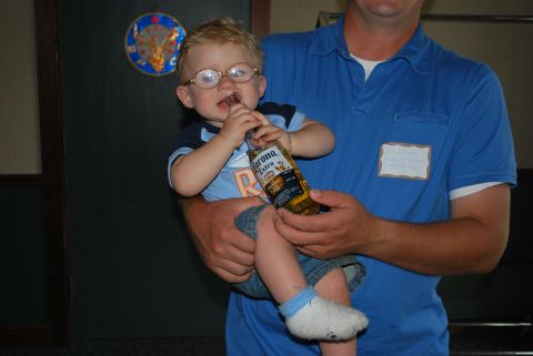 1996 Ford Bronco - A young child wearing glasses holds a Corona Extra bottle to their mouth.