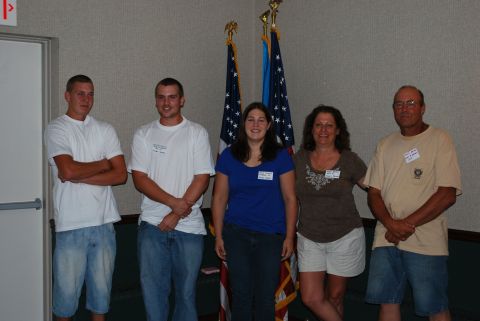 1996 Ford Bronco - A group of people pose for a photo in front of American flags at an indoor event.