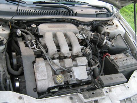 1988 Mercury Grand Marquis - The engine bay of a car is shown, the V6 engine and various components like the battery and air intake system.