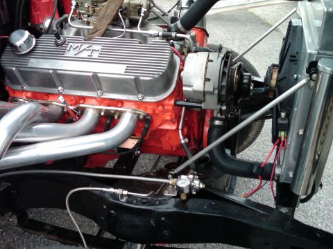 1955 Chevrolet Bel Air - Close-up view of a modified engine with custom valve covers and exhaust headers.