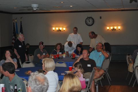 1996 Ford Bronco - Attendees mingle and dine at a reunion event, with American flags visible in the background.