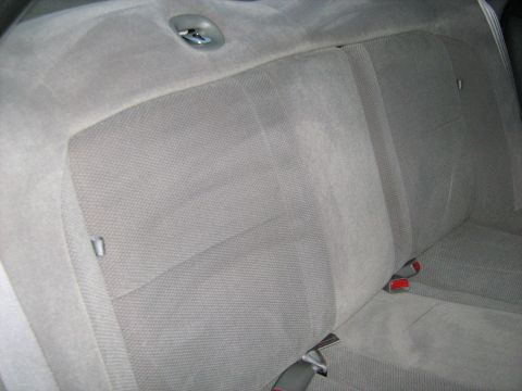 1988 Mercury Grand Marquis - The interior of a car shows the back seat upholstery and seatbelt latches.