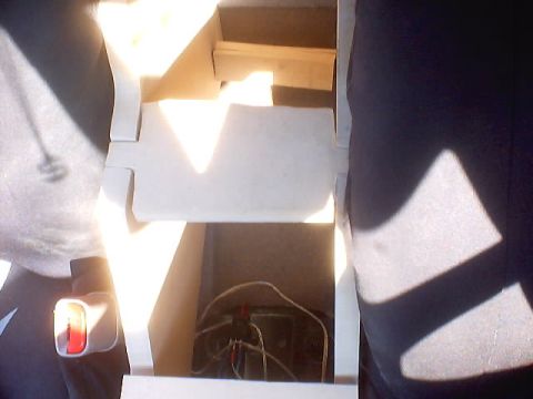 1999 Ford Taurus - The interior storage compartment of a vehicle, showing wiring and a seatbelt buckle.