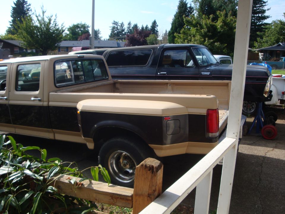 Side view of tan and brown crew cab dually pickup parked in a residential driveway