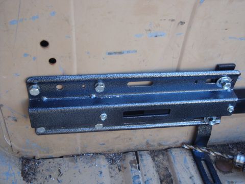 1988 Ford F-350 - Close-up of a black metal bracket attached to a tan surface, showing bolts and some faint text.