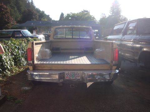 1988 Ford F-350 - Rear view of a tan 1980 Ford F-350 pickup truck with an Oregon license plate parked next to another vehicle.