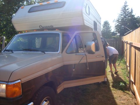 1988 Ford F-350 - Ford F-Series pickup truck with a camper shell, likely from the late 1980s.