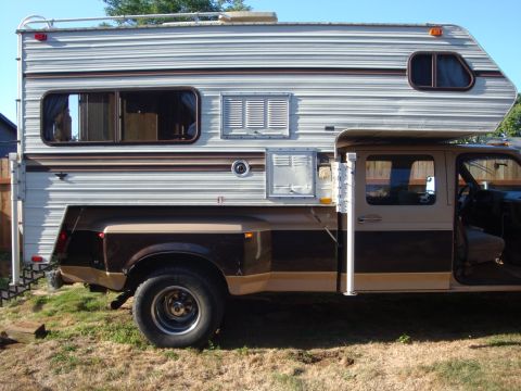 1988 Ford F-350 - This truck appears to be from the 1980s, not 1988, based on its body style and camper shell design.