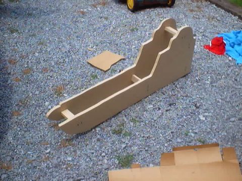 1999 Ford Taurus - A wooden console part is shown outdoors on a gravel surface, with a small separate piece nearby.
