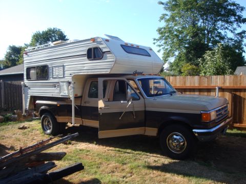 1988 Ford F-350 - This Ford F-350 truck is equipped with a camper shell, suggesting it's set up for travel or extended stays.