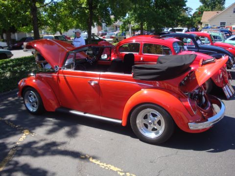 1964 Ford Fairlane - Several Volkswagen Beetles, including a red convertible, are parked at an outdoor car show.