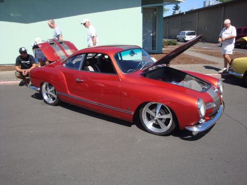 1964 Ford Fairlane - A red coupe with its hood and trunk open is displayed at an outdoor event, with other vehicles and people around.
