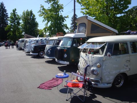 1964 Ford Fairlane - A row of vintage Volkswagen Type 2 buses are parked in a lot on a sunny day.