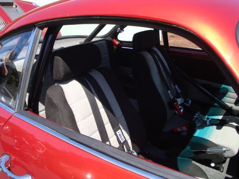 1964 Ford Fairlane - Custom racing seats and roll cage visible inside a red vehicle's interior.