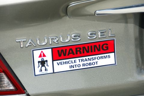 1990 Ford Taurus - 1990 Ford Taurus SEL with a humorous warning sticker about transforming into a robot.