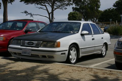 1990 Ford Taurus - 1990 Ford Taurus with a contrasting black hood, parked outdoors.