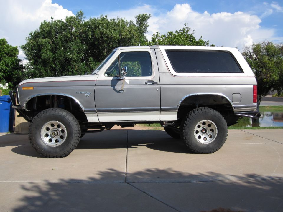 Side view of a lifted 1980 Ford Bronco with two-tone paint and off-road tires