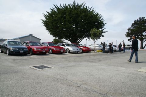 1990 Ford Taurus - A group of sedans are parked in a lot, with a 1990 Ford Taurus among them.