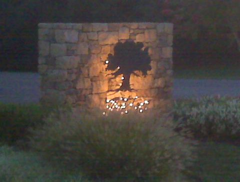1990 Dodge Shadow - A stone monument features a silhouette of a tree illuminated from behind, with small lights at its base.