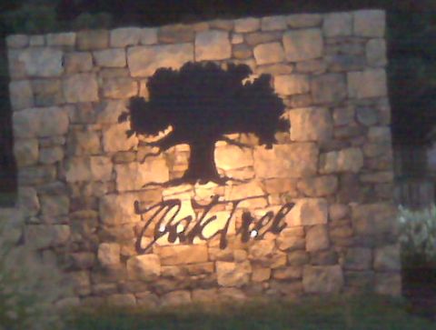 1990 Dodge Shadow - A stone wall features a silhouette of a tree and the name "Oak Tree" in script lettering.