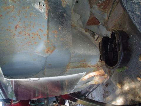 1988 Ford Bronco - Undercarriage view reveals extensive rust on the vehicle's frame and suspension components.