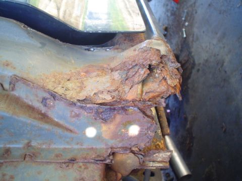 1988 Ford Bronco - Close-up view of severe rust damage on a vehicle's metal frame component.