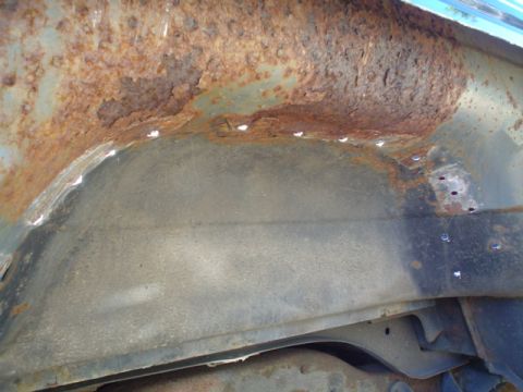 1988 Ford Bronco - The interior of a heavily rusted wheel well shows significant metal degradation and repair attempts.