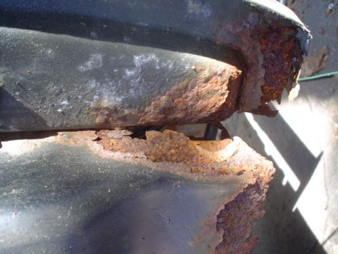 1988 Ford Bronco - Close-up view of severe rust damage on a vehicle's metal component.